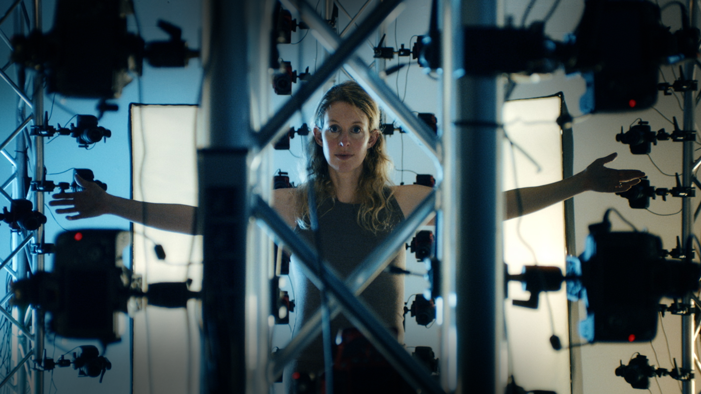 Elizabeth Holmes in You Can See Everything — A24 official still Elizabeth Holmes inside a multi-camera rig in A24 documentary You Can See Everything